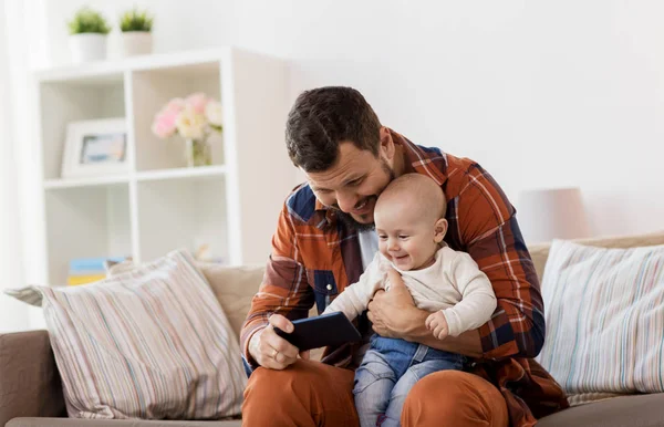 Far och baby pojke med smartphone hemma — Stockfoto