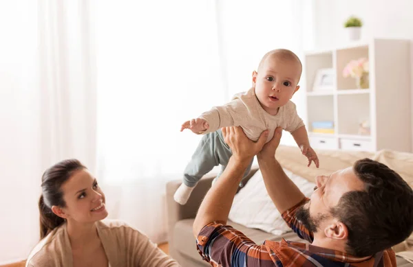 Mãe feliz e pai brincando com o bebê em casa — Fotografia de Stock