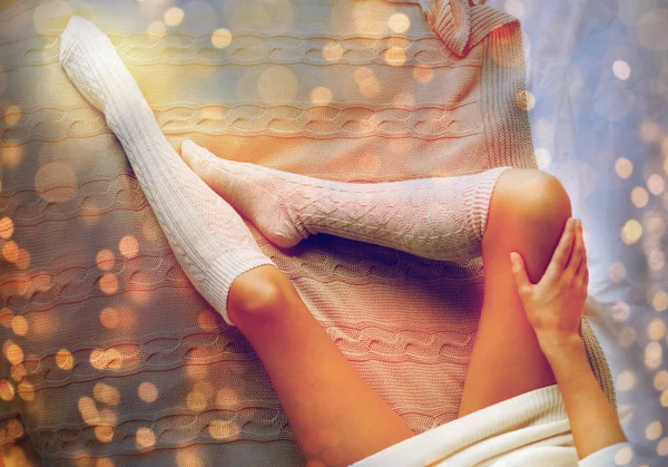 Közelkép a nő lába téli térd zoknit az ágyban — Stock Fotó