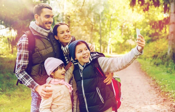 Family with backpacks taking selfie by smartphone — Stock Photo, Image