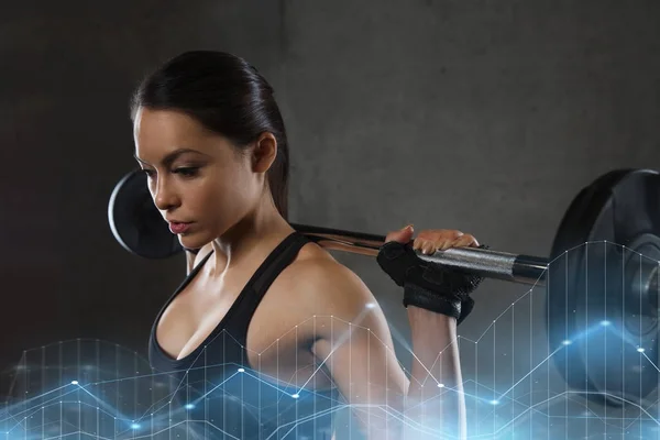 Ung kvinna flexar muskler med skivstång i gym — Stockfoto