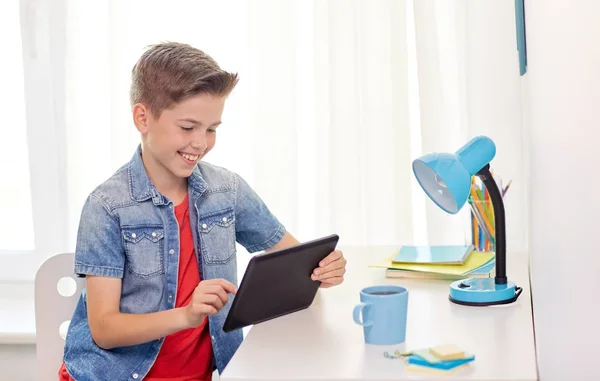 Leende pojke med TabletPC sitter hemma skrivbord — Stockfoto