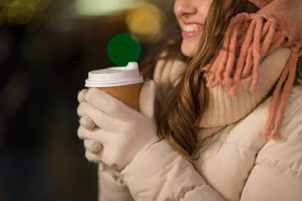 Mujer feliz con café sobre luces de Navidad — Foto de Stock