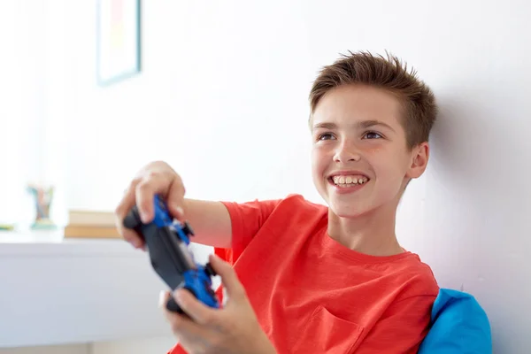 Menino feliz com gamepad jogar videogame em casa — Fotografia de Stock