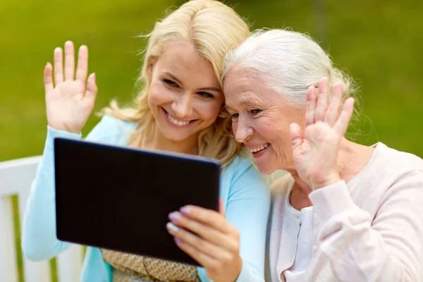 Dotter med tablet pc och senior mor på park — Stockfoto