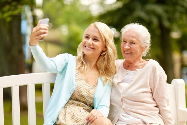 Córka i matka starszy biorąc selfie w parku — Zdjęcie stockowe