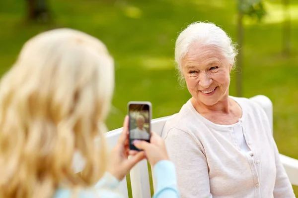 Dotter fotografering senior mor av smartphone — Stockfoto
