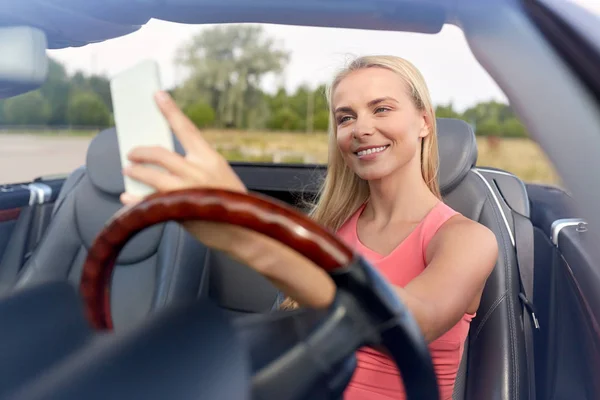 Mujer en coche descapotable tomando selfie —  Fotos de Stock