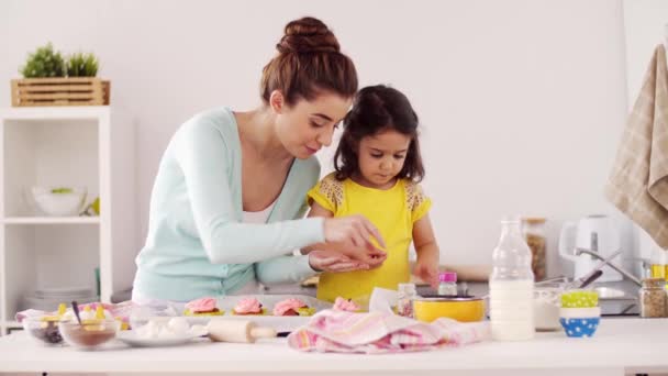 Mother and daughter cooking cupcakes at home — Stock Video