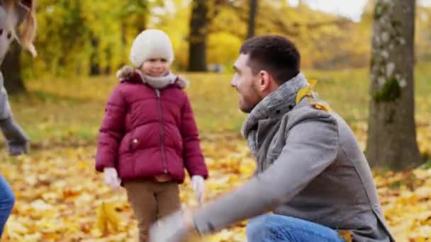 Glückliche Familie spielt im Park mit Herbstlaub — Stockvideo