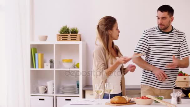 Feliz pareja cocinando y sirviendo comida en casa — Vídeo de stock