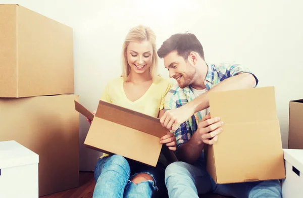 Улыбающаяся пара с большим количеством коробок, переезжающих в новый дом — стоковое фото