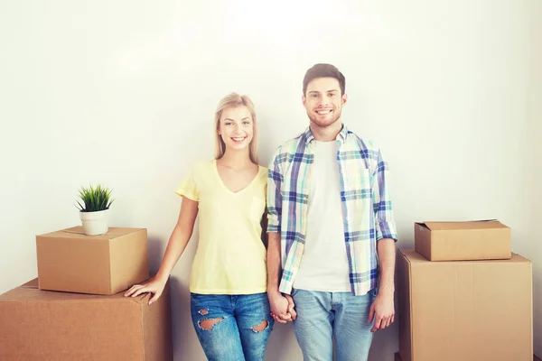 Sonriente pareja con grandes cajas moviéndose a nuevo hogar — Foto de Stock