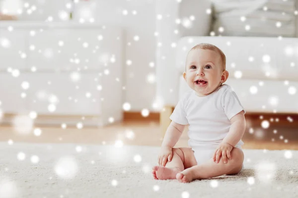 Glad liten pojke eller flicka sitter på golvet hemma — Stockfoto