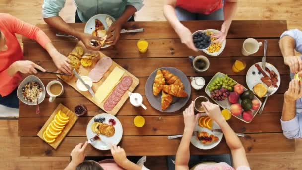 Grupo de pessoas comendo à mesa com alimentos — Vídeo de Stock