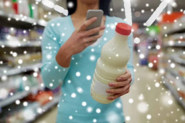 Klant met smartphone en melk bij supermarkt — Stockfoto