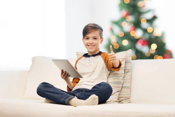 Boy with tablet pc showing thumbs up at christmas — Stock Photo, Image