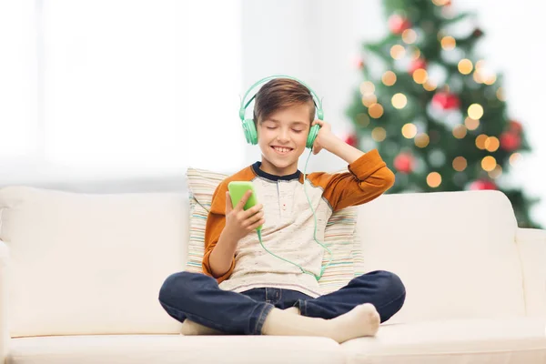 Chłopiec z smartphone i słuchawki na Boże Narodzenie — Zdjęcie stockowe