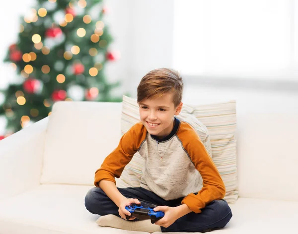 Boy with gamepad playing video game at christmas — Stock Photo, Image