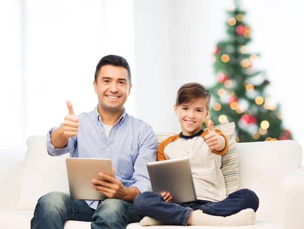 Отец и сын с планшетным компьютером, показывающим вверх большие пальцы — стоковое фото
