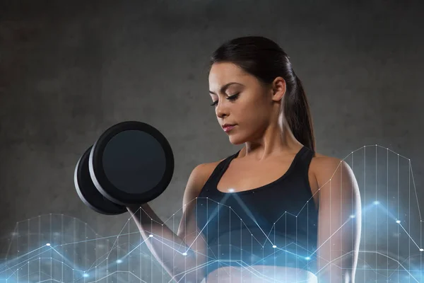 Giovane donna che flette i muscoli con i manubri in palestra — Foto Stock