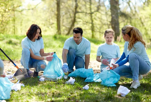 Bénévoles avec sacs à ordures nettoyage de la zone du parc — Photo