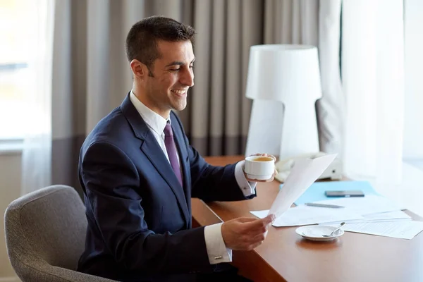 Empresário com papéis bebendo café no hotel — Fotografia de Stock