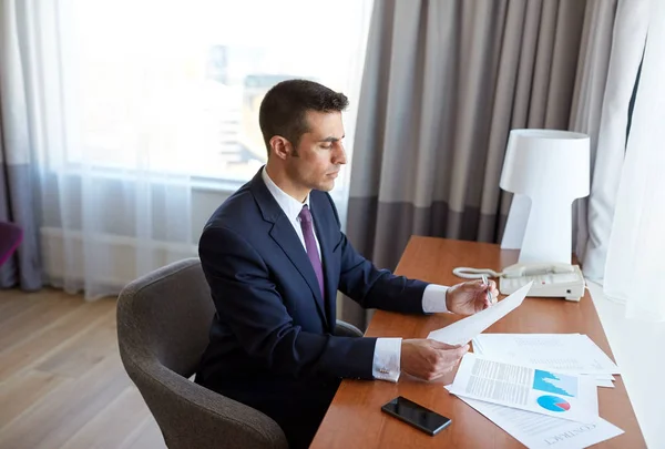 Businessman with papers working at hotel room — Stock Photo, Image