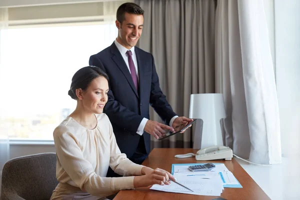 Equipe de negócios com papéis que trabalham no quarto de hotel — Fotografia de Stock