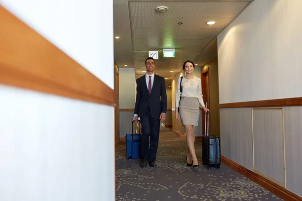 Equipo de negocios con bolsas de viaje en el pasillo del hotel — Foto de Stock