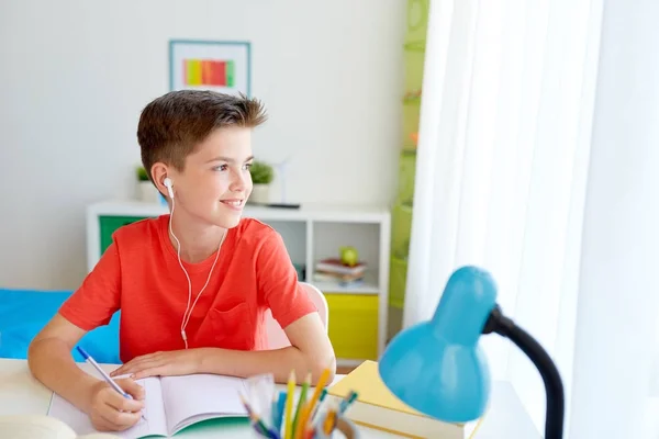 Student szczęśliwy chłopiec piśmie do notebooka w domu — Zdjęcie stockowe