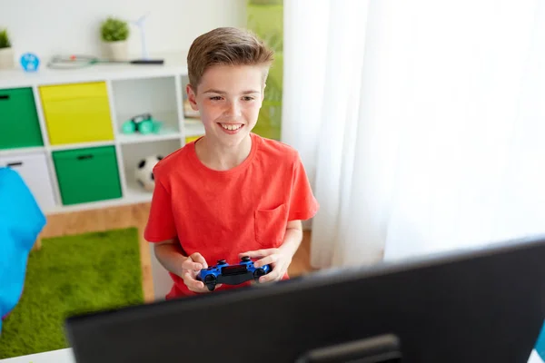 Menino com gamepad jogar videogame no computador — Fotografia de Stock