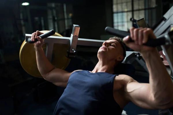 男人做胸部在健身房中锻炼机上的新闻 — 图库照片