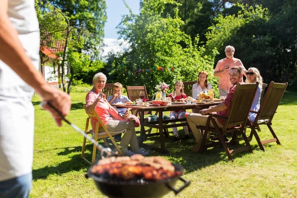 Man cooking meat on barbecue grill at summer party — Stock Photo, Image