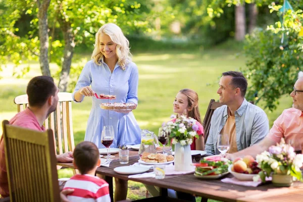 Família feliz ter jantar ou festa no jardim de verão — Fotografia de Stock