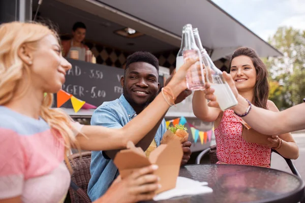 Vrienden rammelende drankjes en eten op de food truck — Stockfoto