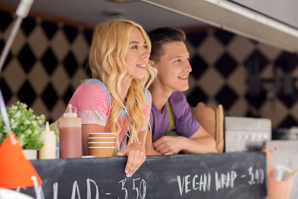 Jovens vendedores felizes no caminhão de alimentos — Fotografia de Stock