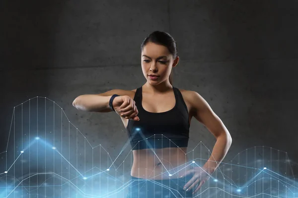 Jeune femme avec montre de fréquence cardiaque dans la salle de gym — Photo