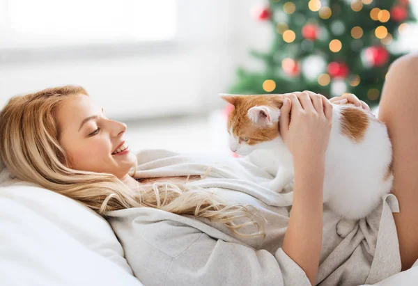 Felice giovane donna con gatto a letto a Natale — Foto Stock