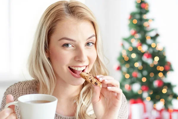 Mujer feliz con el café comer galleta en Navidad —  Fotos de Stock