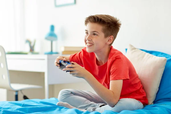 Glad pojke med gamepad spela TV-spel hemma — Stockfoto