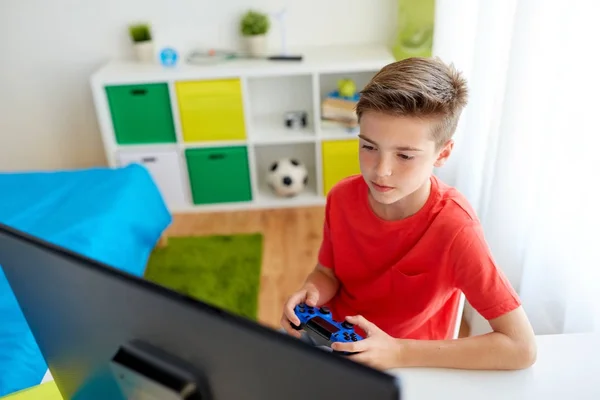 Pojke med gamepad spelar videospel på dator — Stockfoto