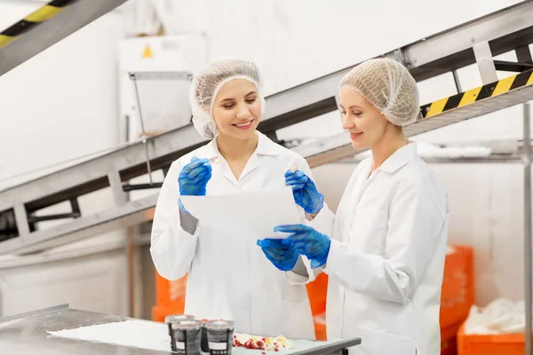 Mujeres tecnólogos degustación de helado en la fábrica — Foto de Stock