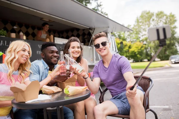 Felices jóvenes amigos tomando selfie en camión de comida — Foto de Stock