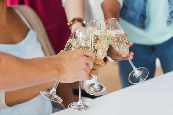 Vänner som spottar glas champagne på fest — Stockfoto