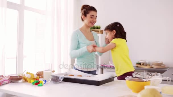 Мама с дочерью готовит и танцует дома — стоковое видео