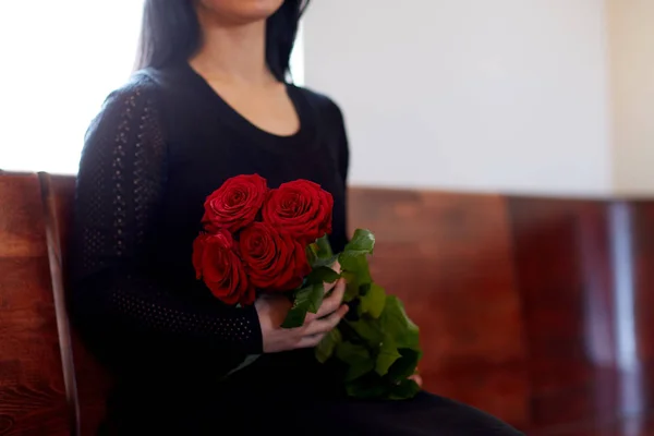 Gros plan de la femme avec des roses aux funérailles à l'église — Photo