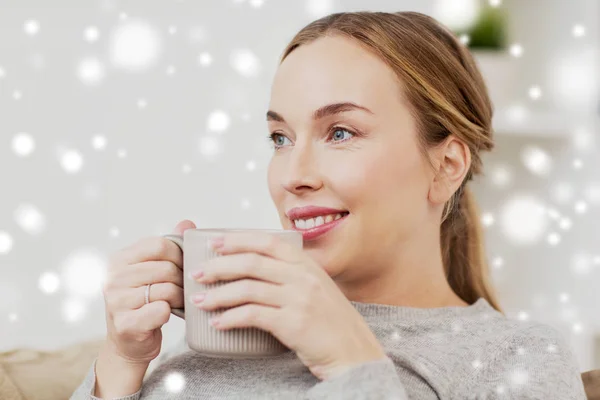 Gelukkige vrouw met kopje of mok thuis drinken — Stockfoto