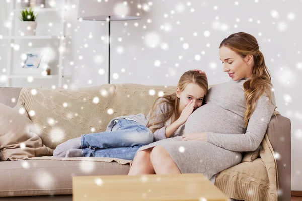 Zwangere vrouw en meisje praten met baby in de buik — Stockfoto