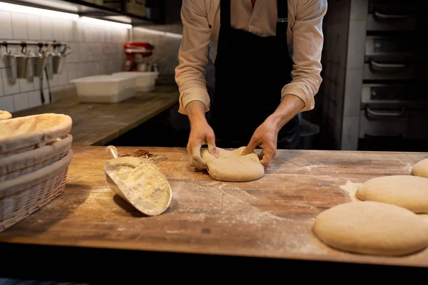 Пекарь порции теста со скамейкой резак в пекарне — стоковое фото